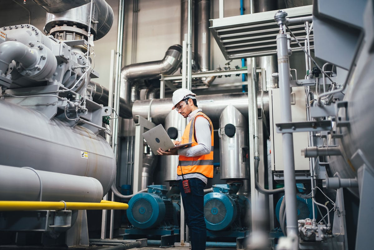 man wearing a hard hat while standing in an industrial plant