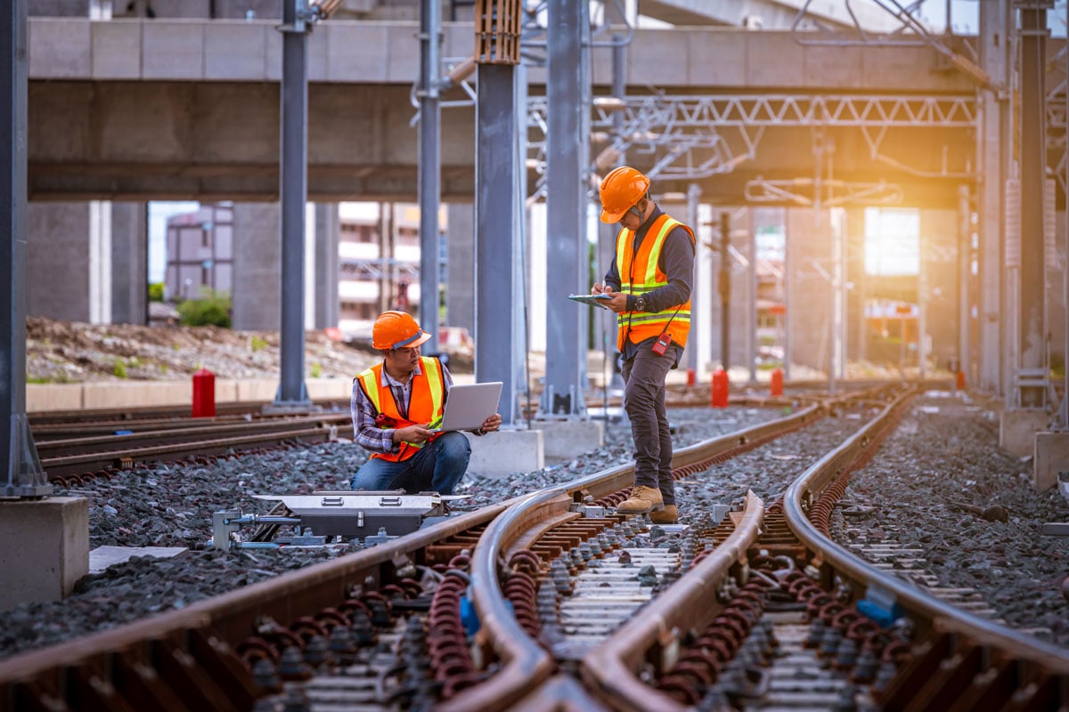 two construction people doing work on a railway