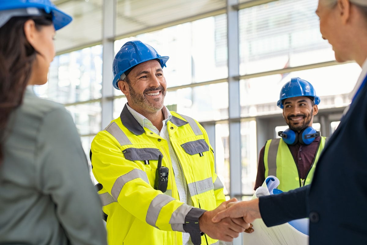 contractor shaking the hands of other stakeholders